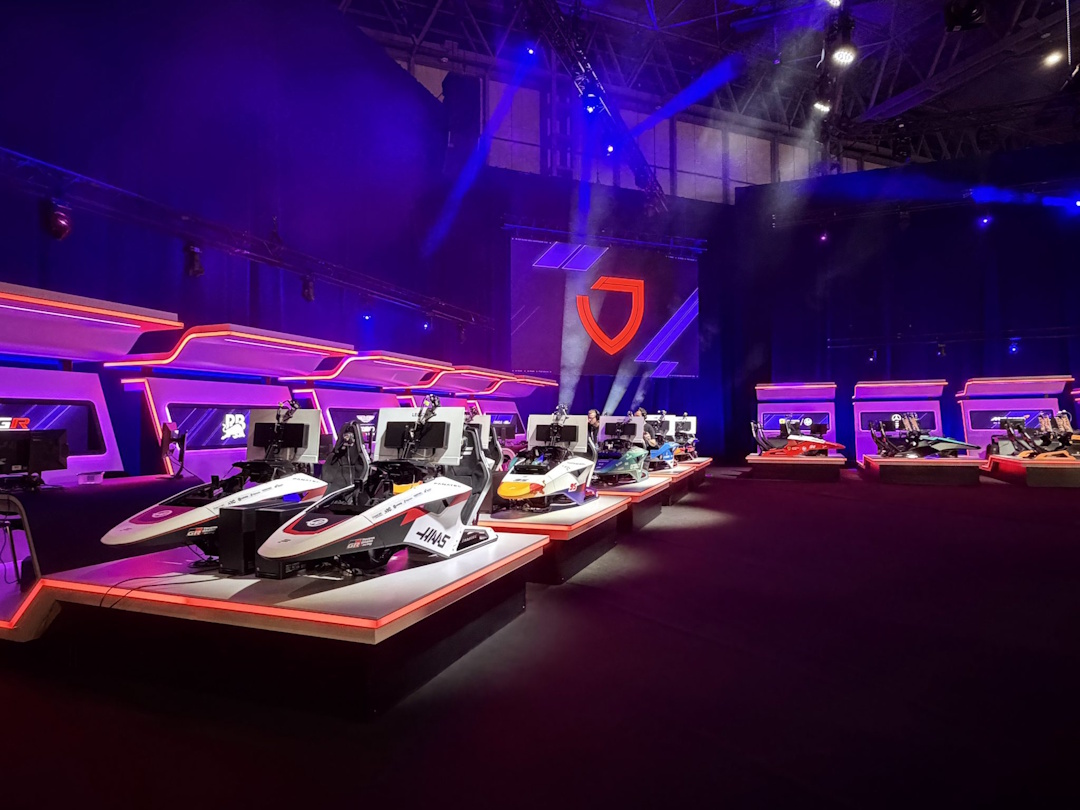Fila de simuladores de corrida profissionais com cockpits de Fórmula 1 e hardware Lenovo Legion numa arena de eSports iluminada a roxo.