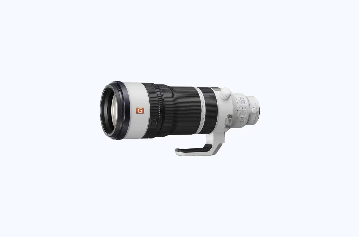 Uma imagem da lente superteleobjetiva zoom Sony FE 100-400mm G Master flutuando contra um fundo branco. A lente é predominantemente branca com anéis de zoom e foco pretos e apresenta o logotipo laranja "G". Um pé de montagem para tripé branco está fixado na parte inferior.