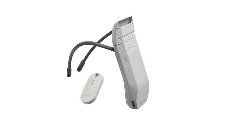 Fotografia de estúdio do Sony Reon Pocket Pro Plus num fundo branco, mostrando o dispositivo de arrefecimento principal com uma banda de pescoço preta flexível, acompanhado à esquerda pela pequena etiqueta inteligente Pocket Tag branca.