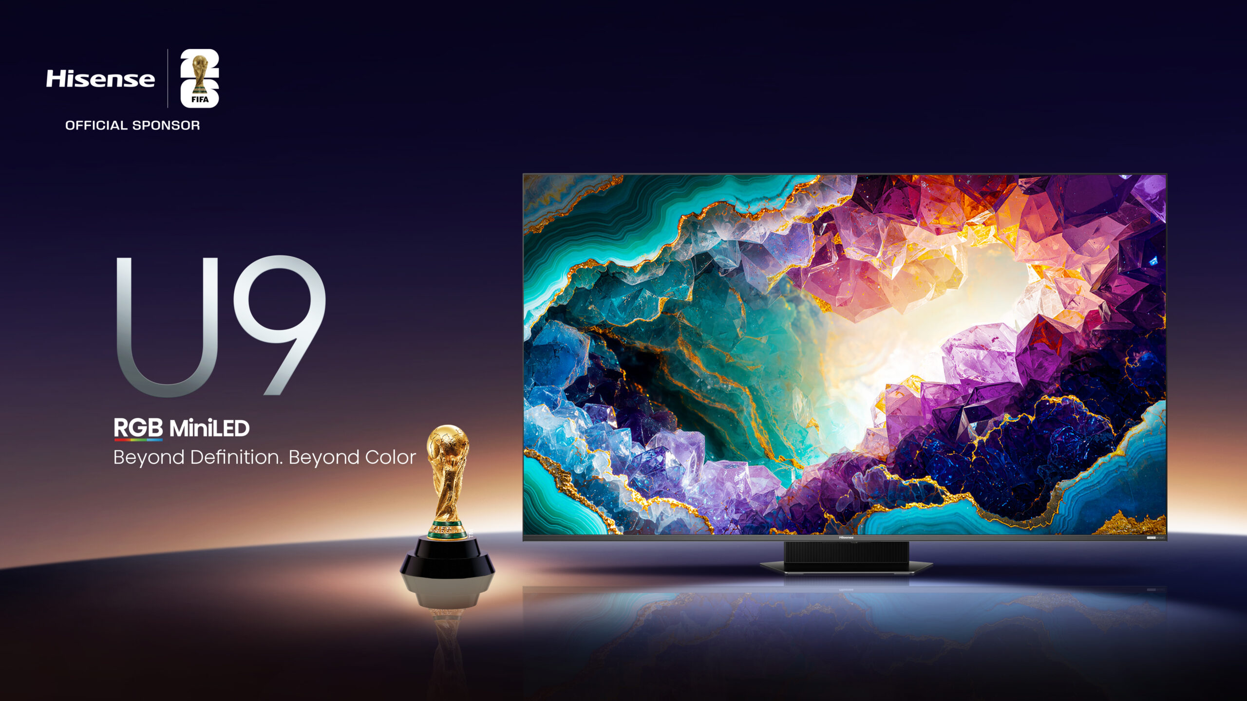 Cartaz publicitário da televisão Hisense U9 RGB MiniLED, patrocinadora oficial da FIFA. A imagem mostra o televisor de design moderno exibindo cristais coloridos e brilhantes, ao lado do troféu original do Campeonato do Mundo de Futebol, sobre um fundo escuro e elegante com reflexos na base.
