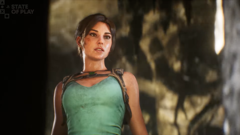 Lara Croft em destaque a usar o seu clássico top turquesa e arnês de pele, com uma expressão focada e o rosto com marcas subtis de sujidade. O cenário de fundo é uma gruta rochosa desfocada, iluminada por luz natural à direita. No canto superior esquerdo encontra-se o logótipo "PlayStation State of Play".
